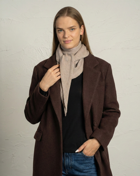 Creamy beige merino wool knit bandana scarf wrapped around a woman’s neck.