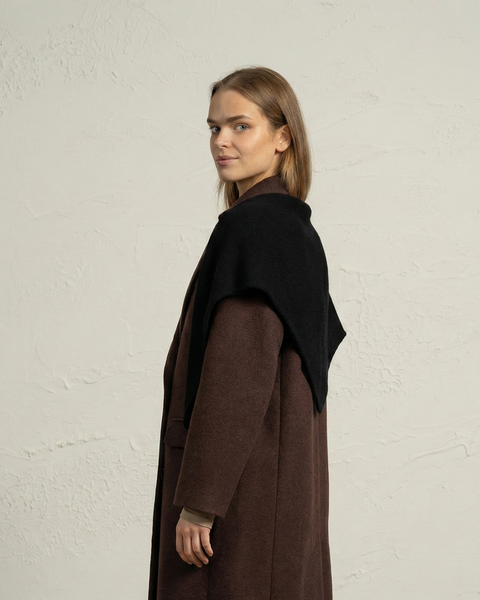 Side view of woman wearing black knit merino bandana as a shoulder wrap.