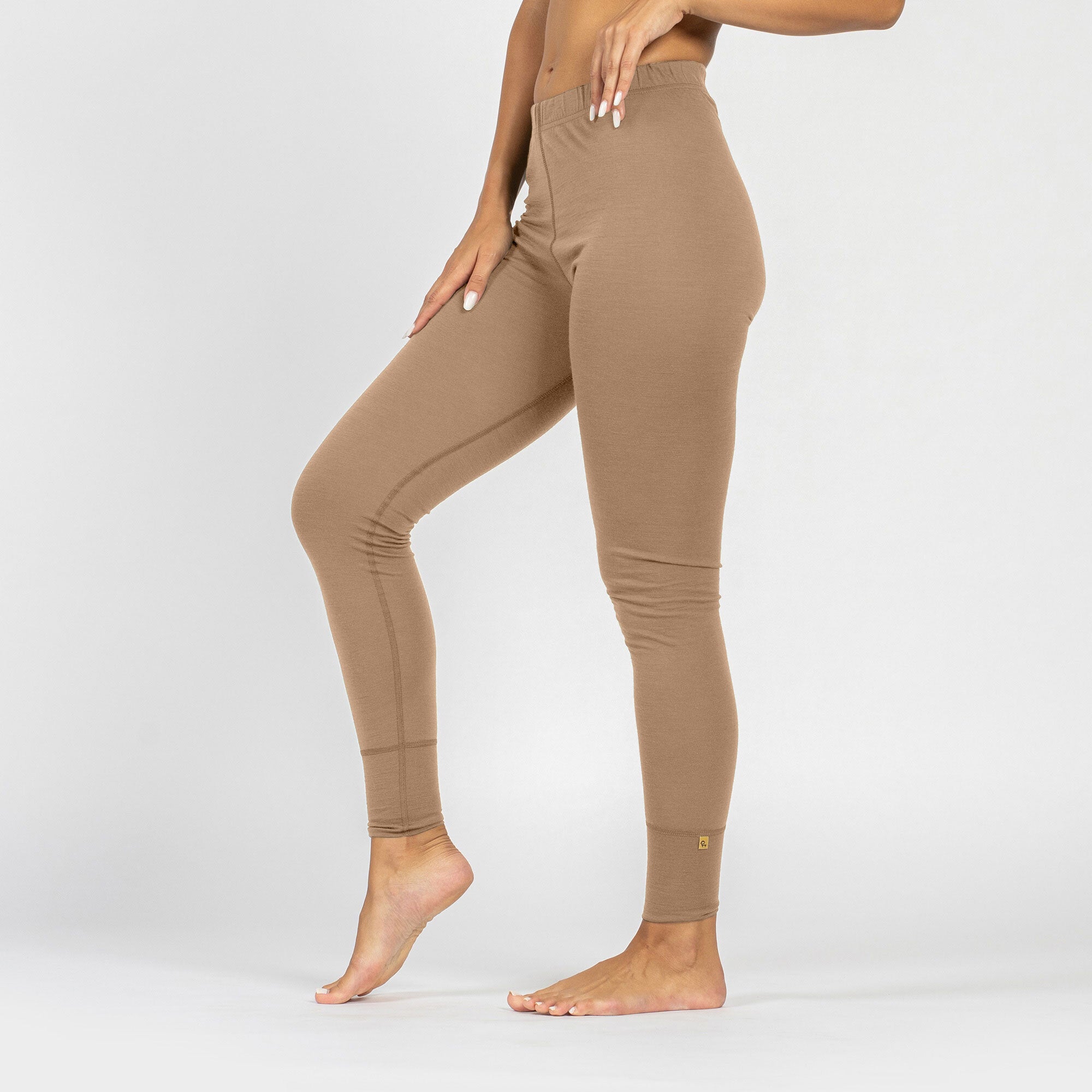 Women’s natural beige merino wool thermal leggings, back view.