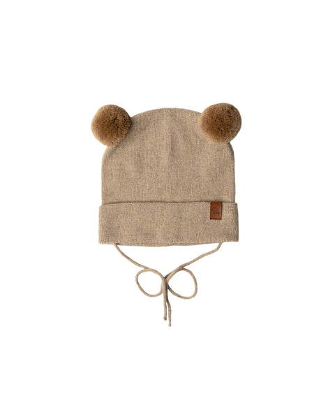 Creamy beige baby beanie with pom-pom ears and chin ties on white background