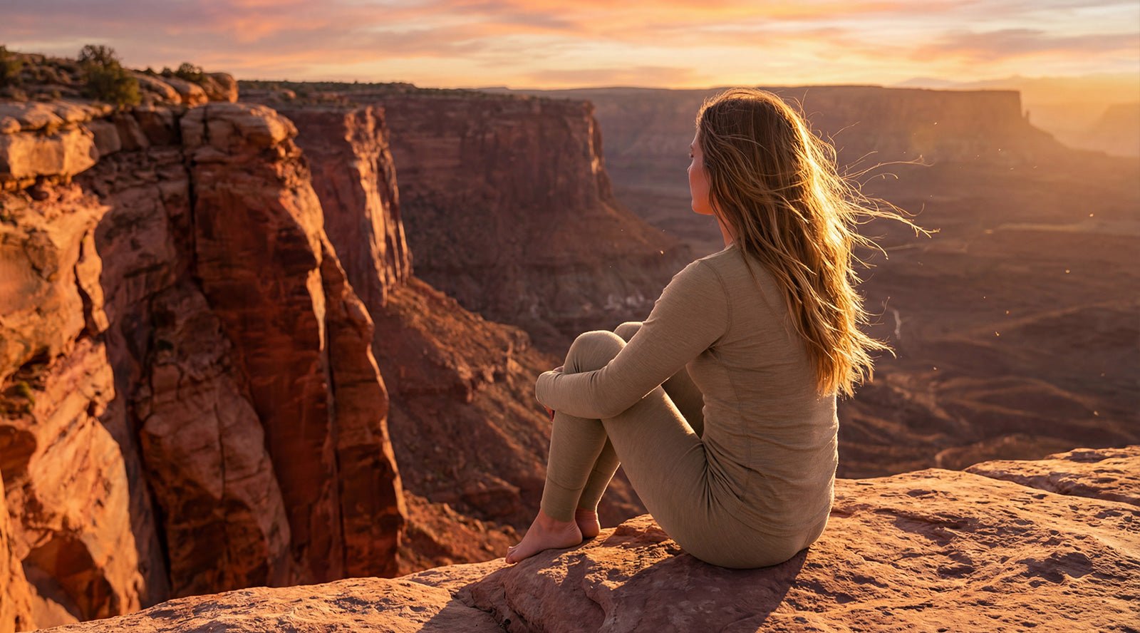 In the photo you can see woman standing, behind her there are exercising tools, such as weights. The woman is wearing black tank top with leggings made from organic 100% Merino Wool.