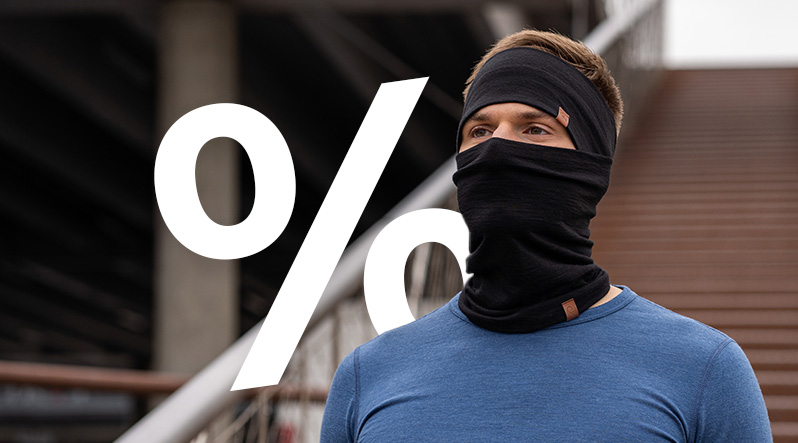 a man stretching his leg, wearing a sleeveless black merino top and a denim color merino headband. The banner text reads "UP TO 50% OFF".