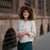 Woman with curly hair wearing almond brown linen jacket Alice and standing in  astreet