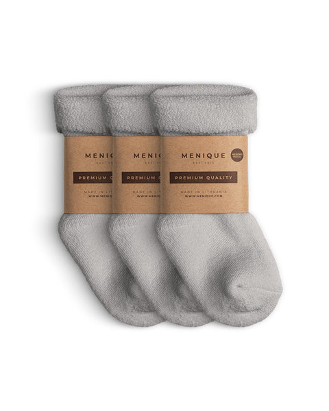 A 3-pack of kids’ light gray sherpa-lined merino wool socks with Menique branding.