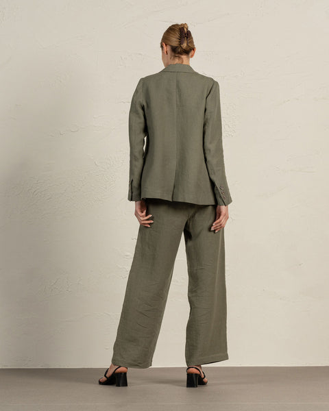 Back view of Linen Blazer Quin in olive green, showing tailored fit and full-length trousers by Menique
