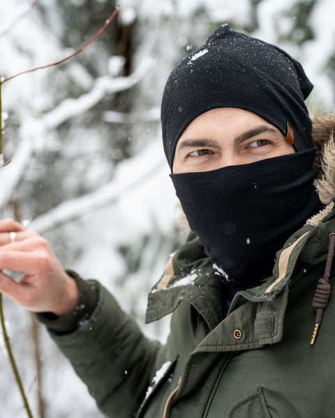 Menique Men&#39;s Merino Beanie and Gaiter Accessory Set worn by a man, in winter time. The set is in black color.