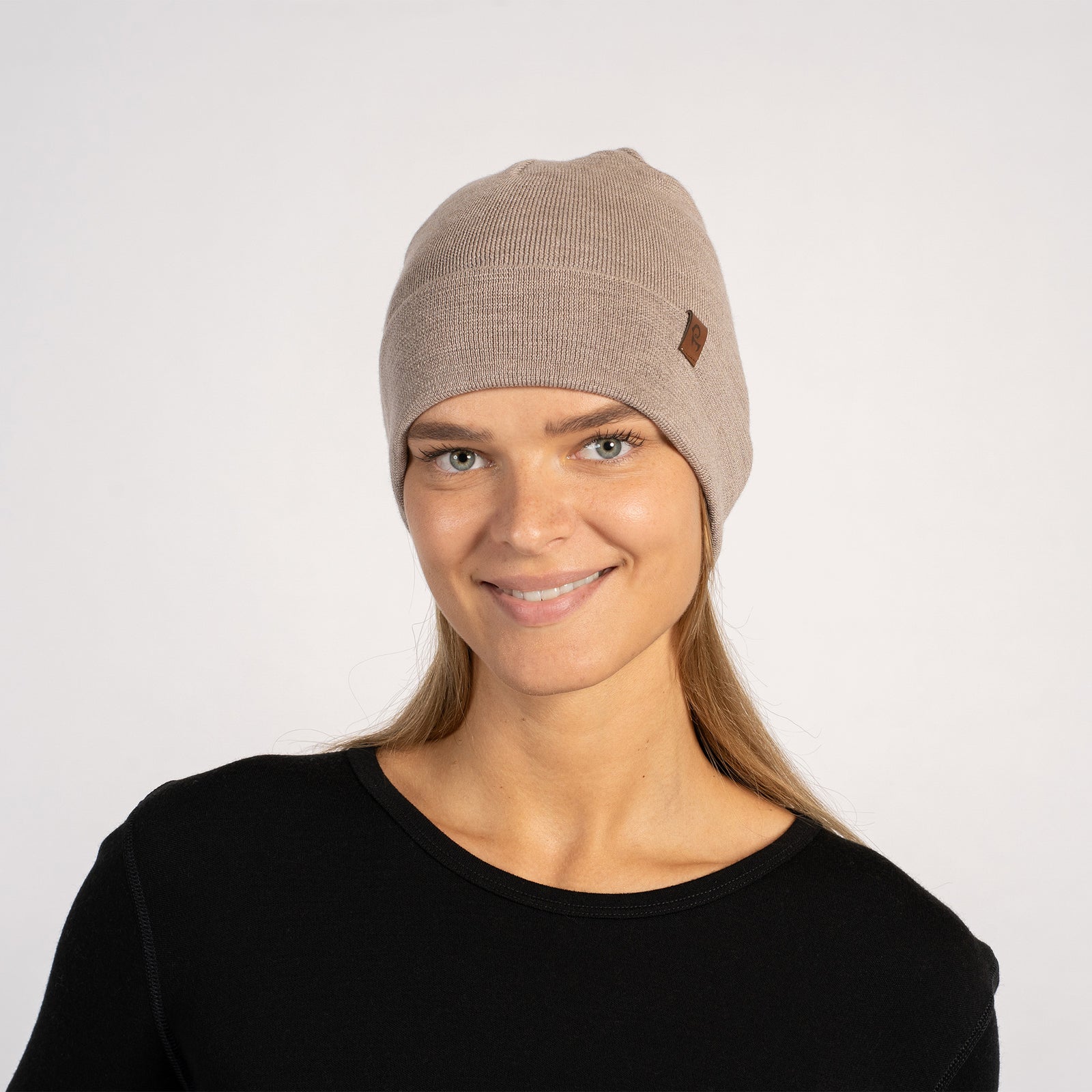 Side view of woman in a dark gray knitted Merino wool beanie, paired with a red shirt.
