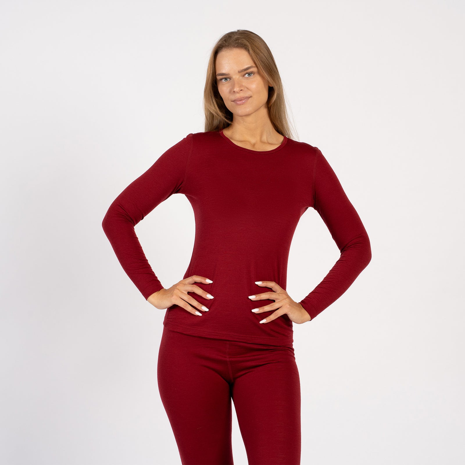 Side view of woman wearing royal cherry Merino wool thermal base layer set.