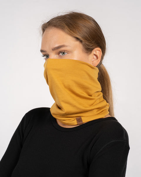 Side view of woman with yellow Merino wool gaiter covering lower face.