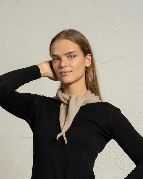 Woman wearing creamy beige knit cashmere Merino bandana tied in front.