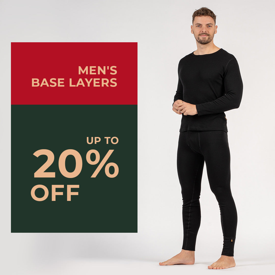 A man standing visible in full height, dressed in black merino wool clothing. There is a banner announcement of 20% off men's base layers.