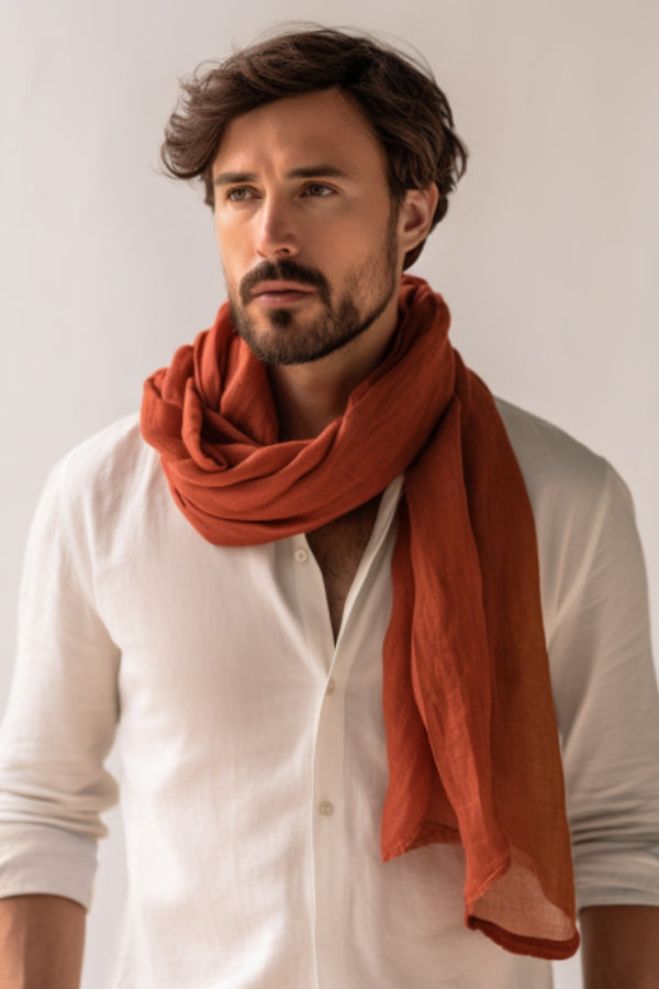 Man wearing white linen shirt and cinnamon red linen scarf.