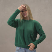 A woman wearing the menique cotton sweater SONATA in dark green color.