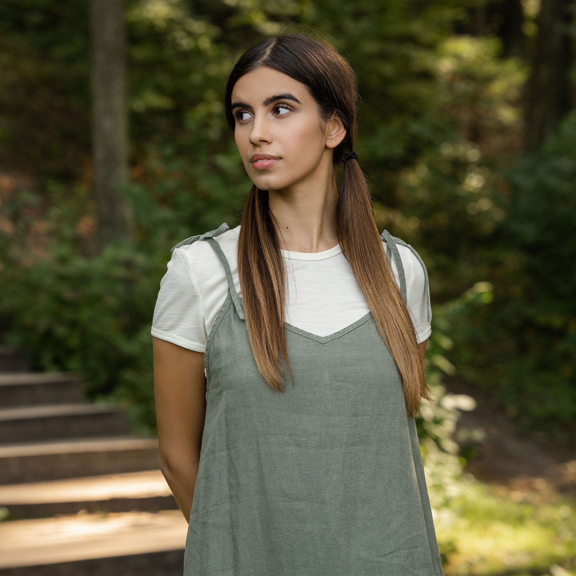 Woman standing in the forest and wearing slip dress from linen 