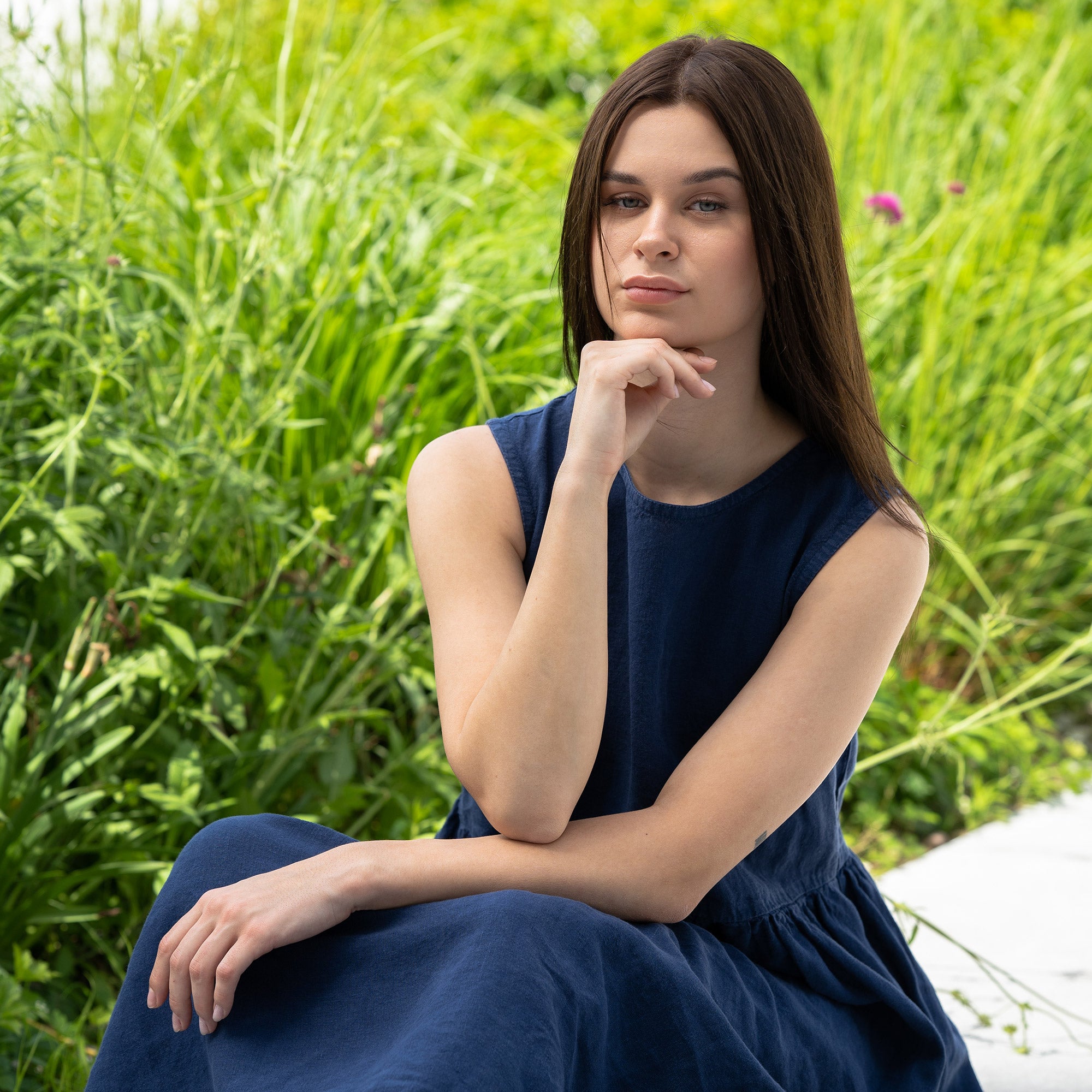 Young woman posing in a city, wearing linen smock dress Maya in a Storm blue cover.