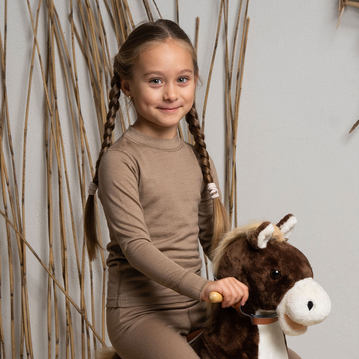 the menique kids' 160gsm merino long sleeve top in beige color, front view.